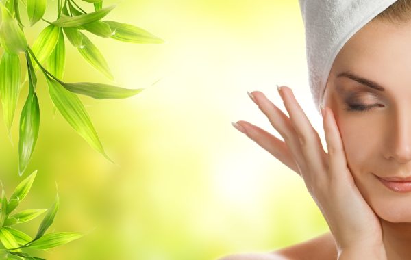 Beautiful young woman applying organic cosmetics to her skin